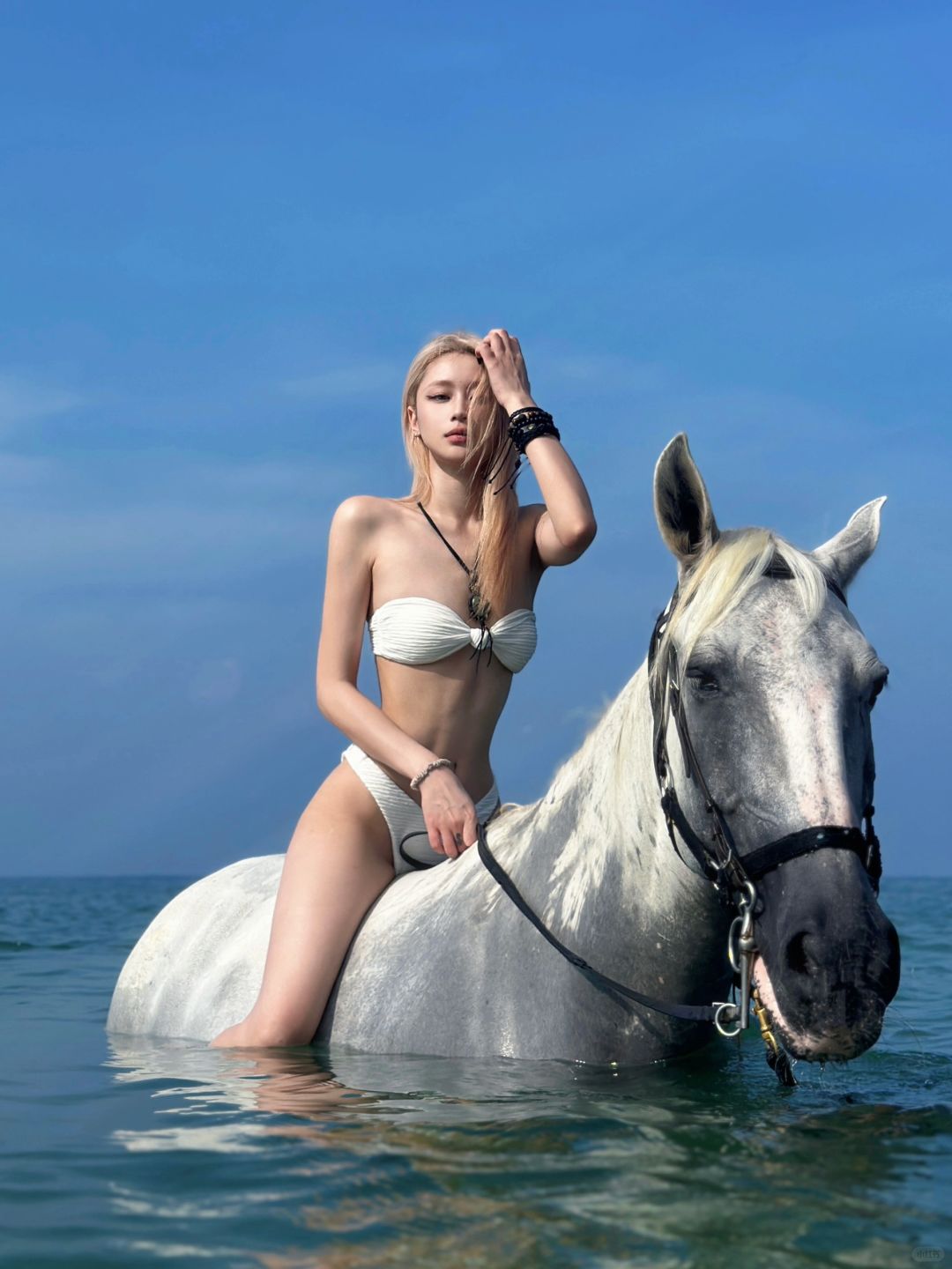 Phuket-Beautiful girl traveling on horseback riding on the beach in Phuket with clear sea and sky