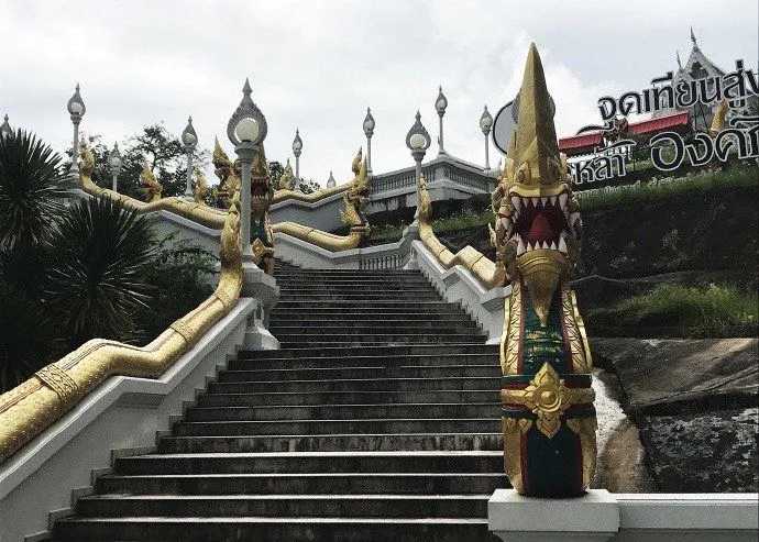 Krabi-The handrails on both sides of the steps at Wat Kerawaram in Krabi are golden dragons connected end to end.