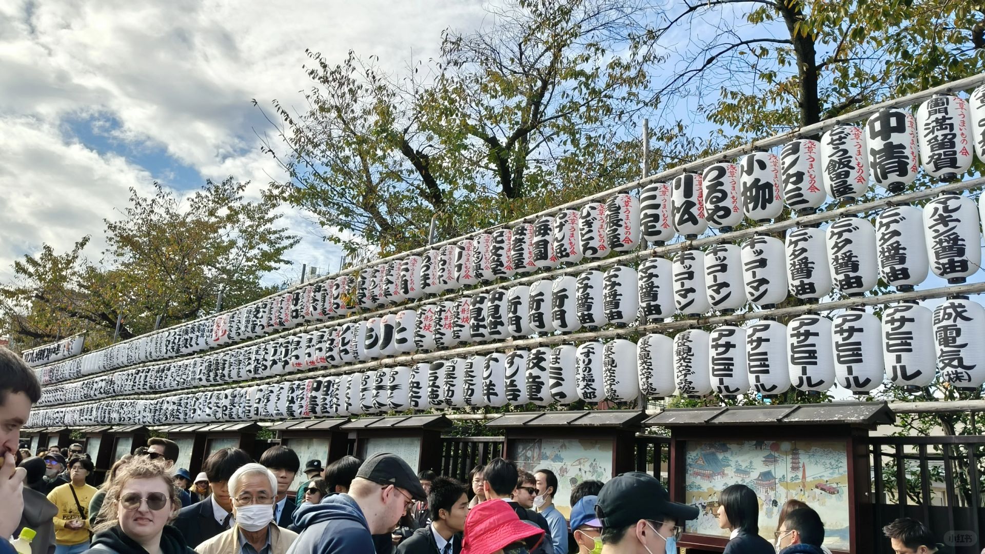 Tokyo-Sensoji Temple crowded with people has red beams and black tiles next toAsakusa Shrine