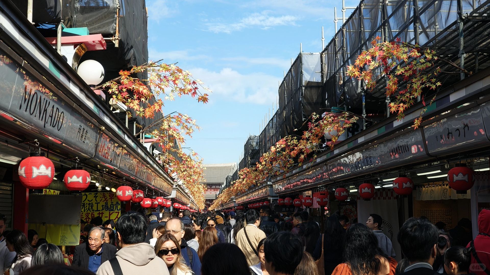 Tokyo-Sensoji Temple crowded with people has red beams and black tiles next toAsakusa Shrine