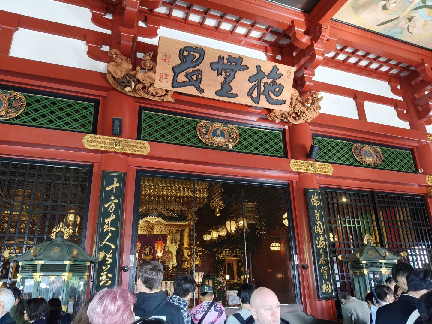 Tokyo-Sensoji Temple crowded with people has red beams and black tiles next toAsakusa Shrine
