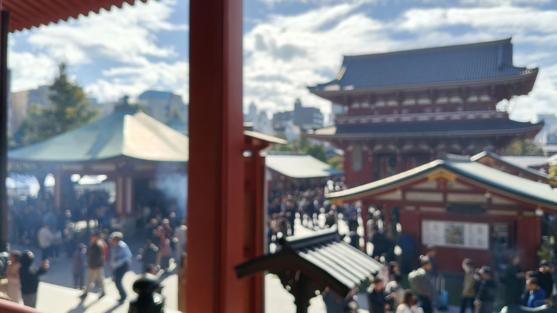 Tokyo-Sensoji Temple crowded with people has red beams and black tiles next toAsakusa Shrine